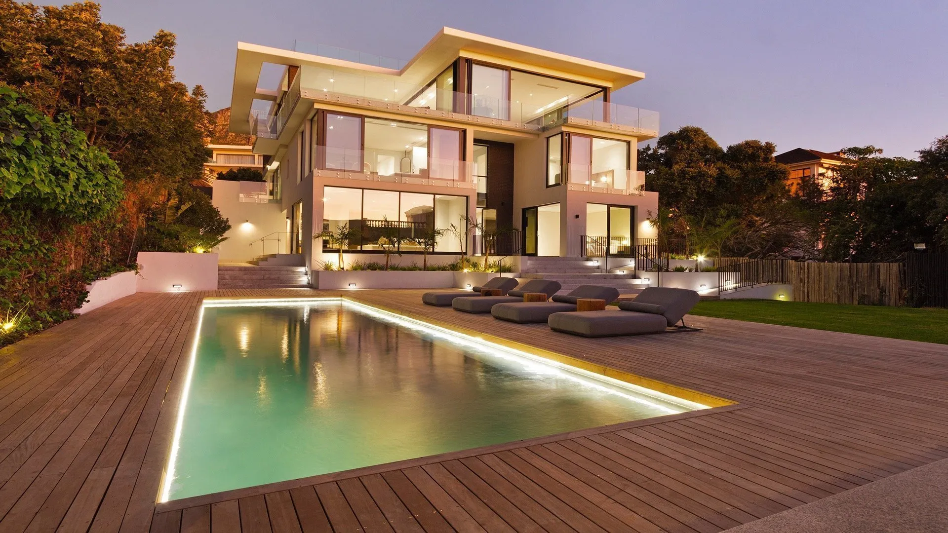 Private villa and illuminated pool at dusk