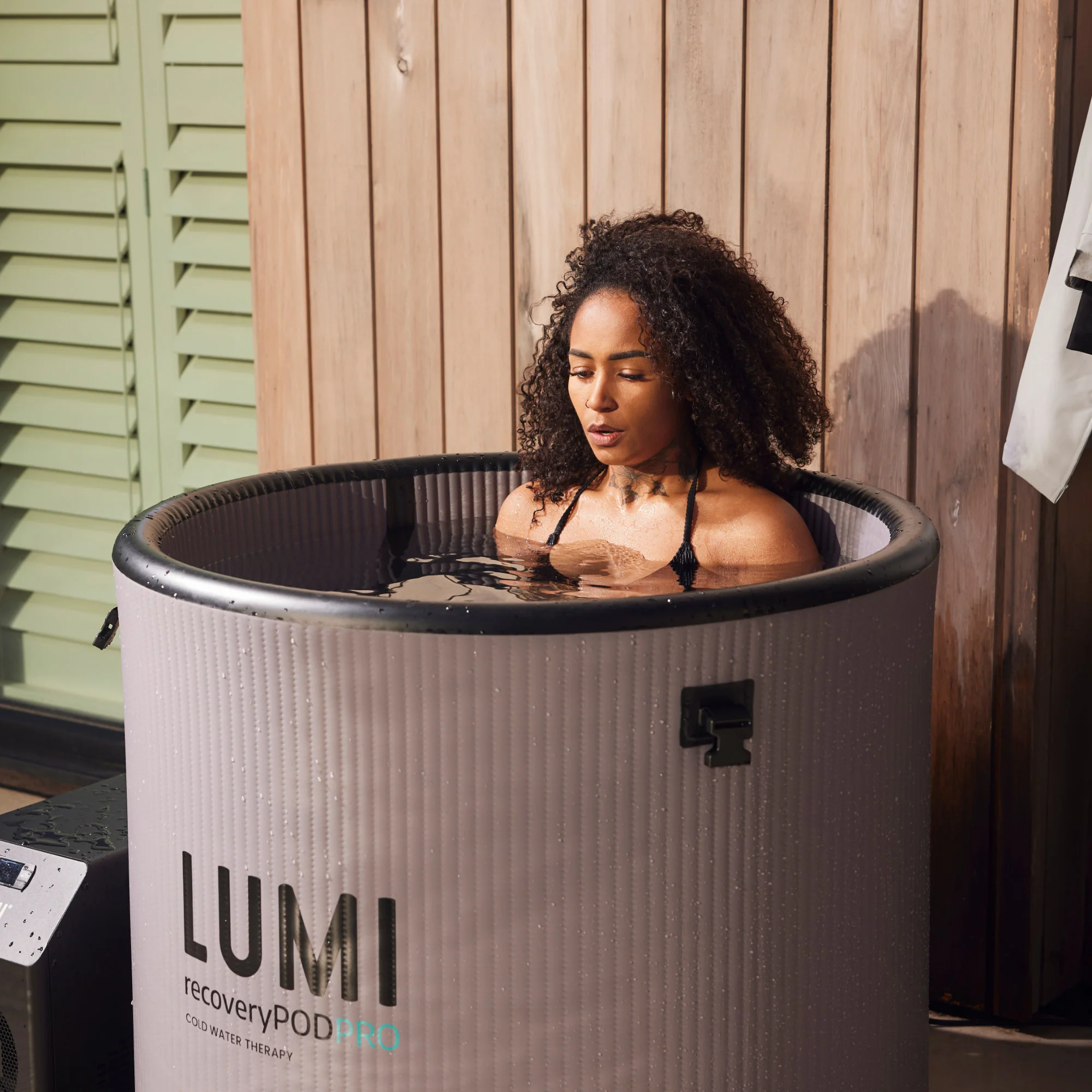 Woman in a private ice bath recovery pod